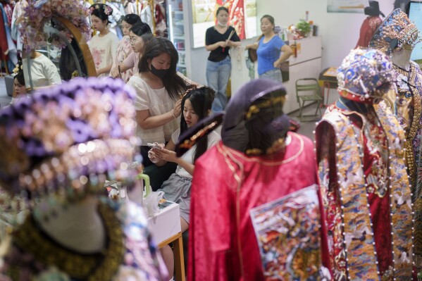 A Chinese girl gets her hair done up at a business building that provides one stop service for the Qing Dynasty traditional look, in Beijing, China, Sunday, July 21, 2024. (AP Photo/Vincent Thian)