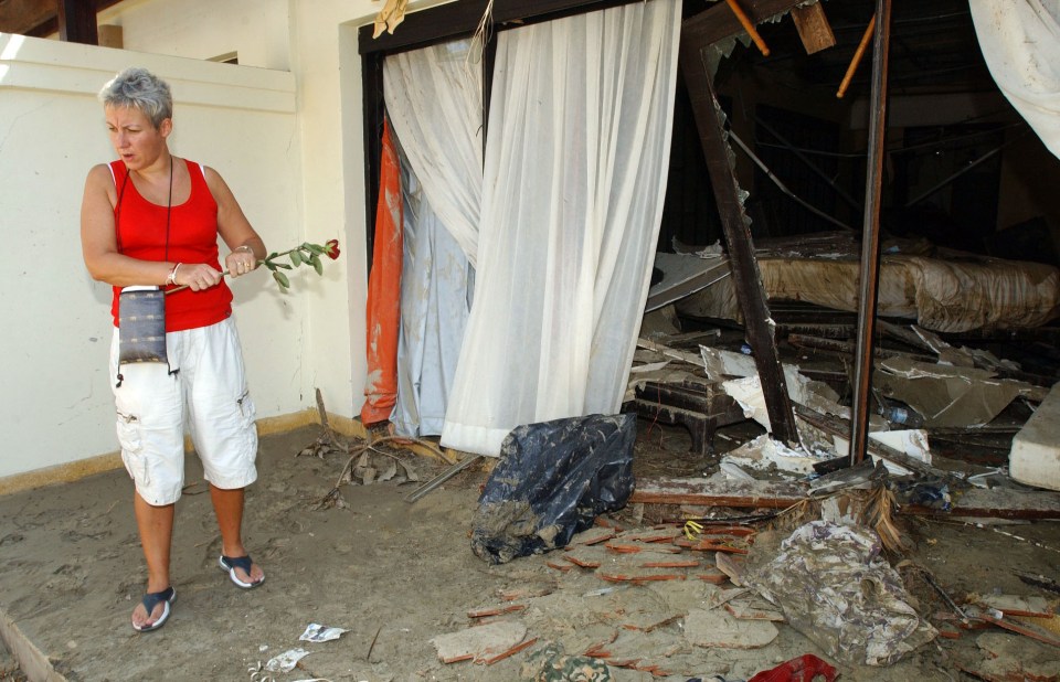 Sharon Howard sobs as she lays flowers at the Thailand hotel where she last saw her fiance and two sons 20 years ago