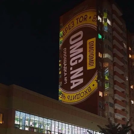 A darknet platform’s logo is projected on to the side of a tower block