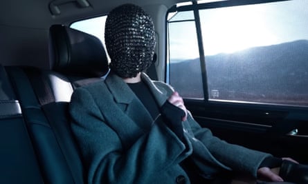 A woman in a mask sitting inside a vehicle