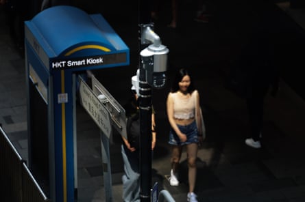 A woman walks past a security camera at night