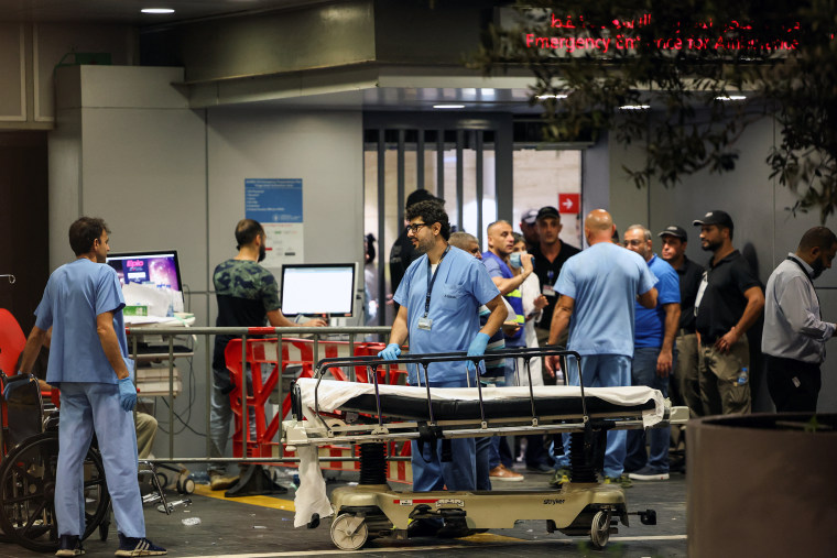 Hospital workers around an empty stretcher