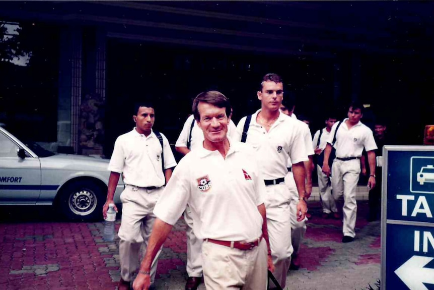 Men walk along the road in soccer polo shirts 