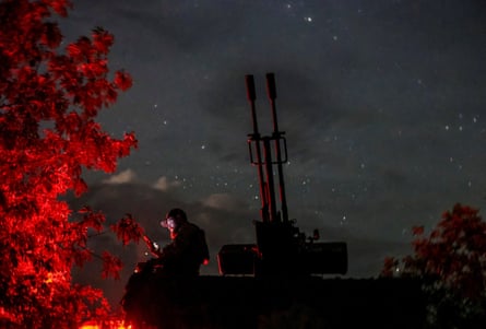 A Ukrainian serviceman from an anti-drone mobile air defence unit uses his mobile device near an anti aircraft cannon as he waits for Russian kamikaze drones in Kherson region, in June.