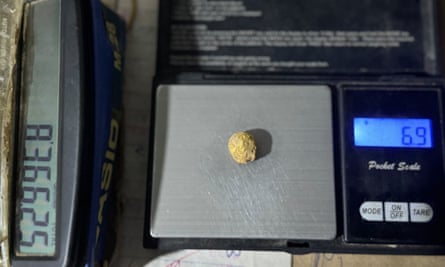 A lump of gold on a scale that records 6.9g in weight