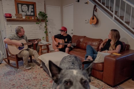 three people and a dog seated in a living room