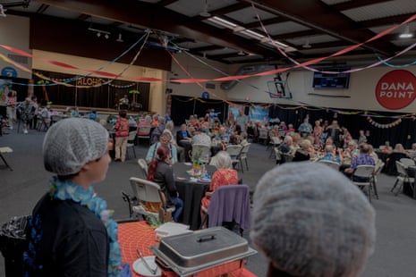 a crowd of people at tables under streamers in a huge room