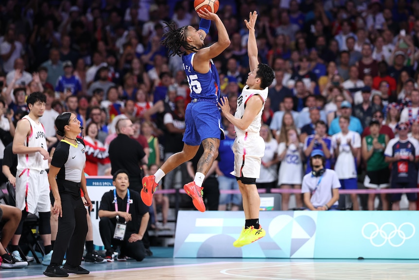 Matthew Strazel shoots a three pointer against Japan