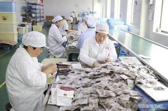 Workers pack up products at a company in Tonglu County of Hangzhou, east China's Zhejiang Province, Nov. 4, 2020. Companies started to prepare for the upcoming Singles Day sale, an online shopping festival. (Photo by Xu Junyong/Xinhua)