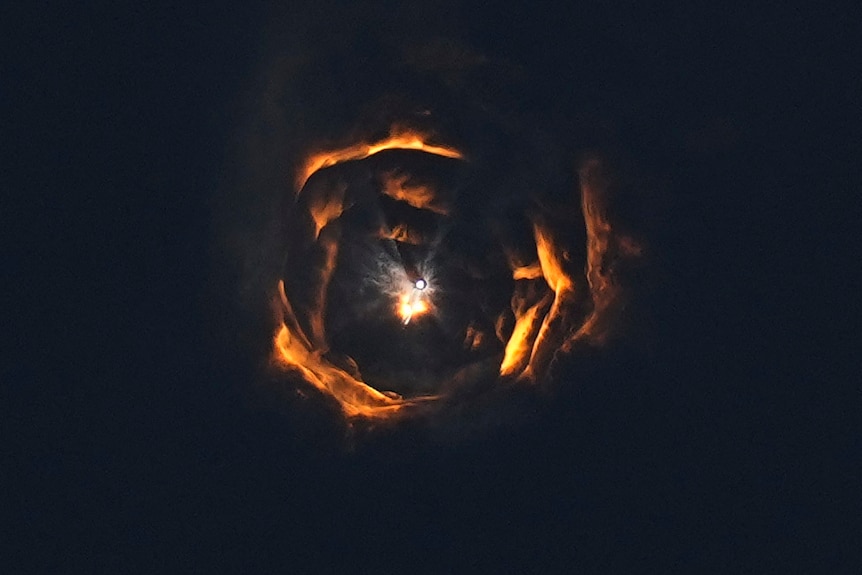 Rings of light form in the sky around a single dot 