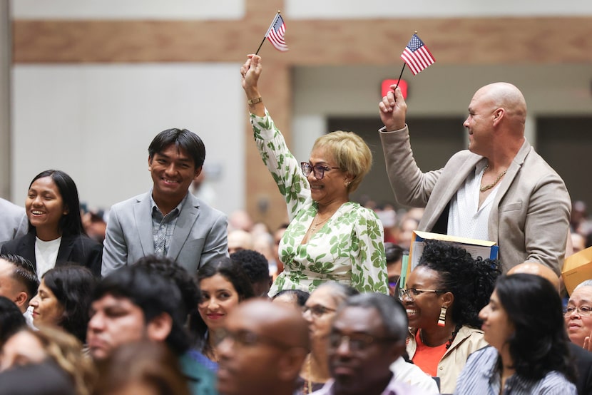 People wave the United States flag after their native country’s name was announced during a...