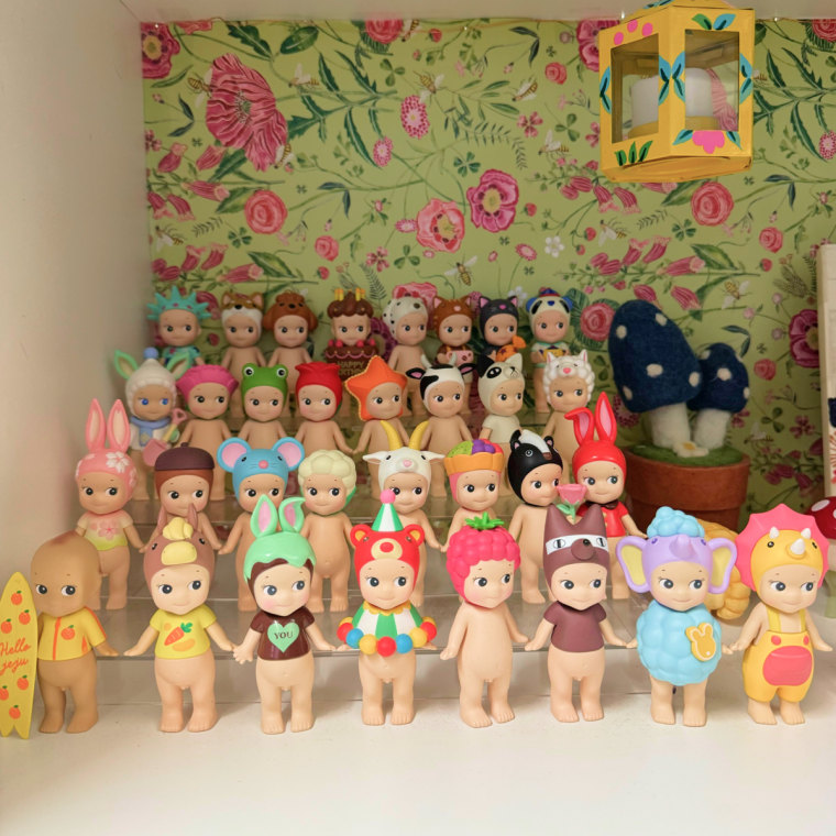 32 Sonny Angel figurines lined up in four rows of eight on a display stand.