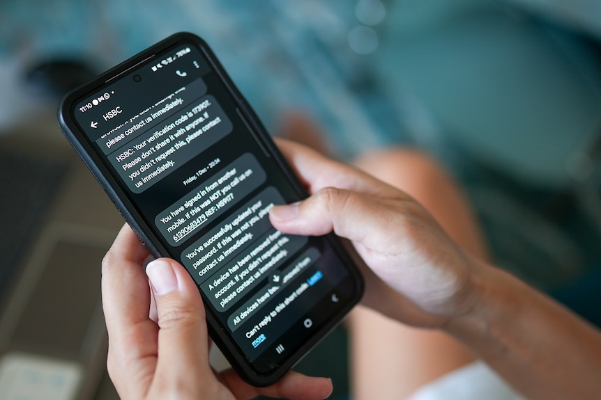 A close up of hands holding a phone filled with text messages from HSBC