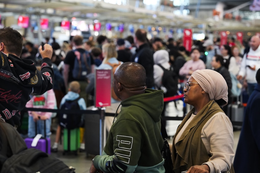 A line of people snake around an airport security line