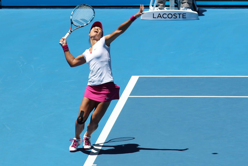 Chinese player Li Na serves on a blue court.