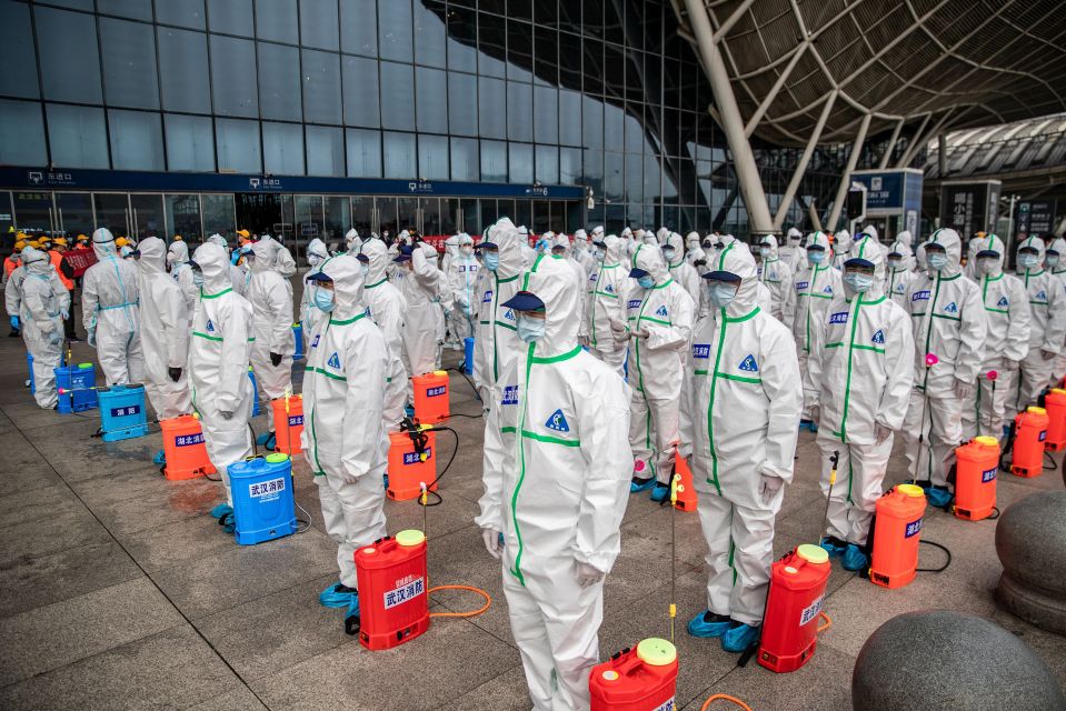 Staff members line up at a Chinese Railway Station in Wuhan ready to spray disinfectant during the height of the Covid pandemic in 2020