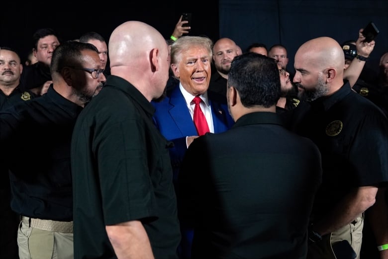 Republican presidential nominee former President Donald Trump talks with members of the U.S. Border Patrol before speaking at a campaign rally, Sunday, Oct. 13, 2024, in Prescott Valley, Ariz.