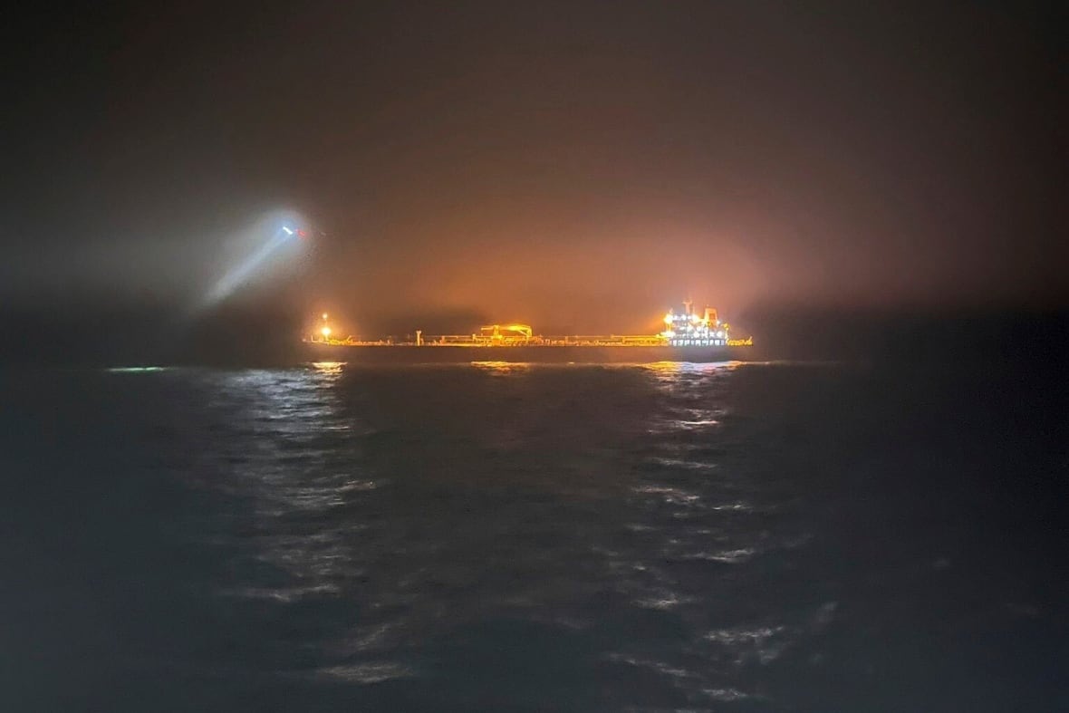 An oil tanker is seen in the water at night time.