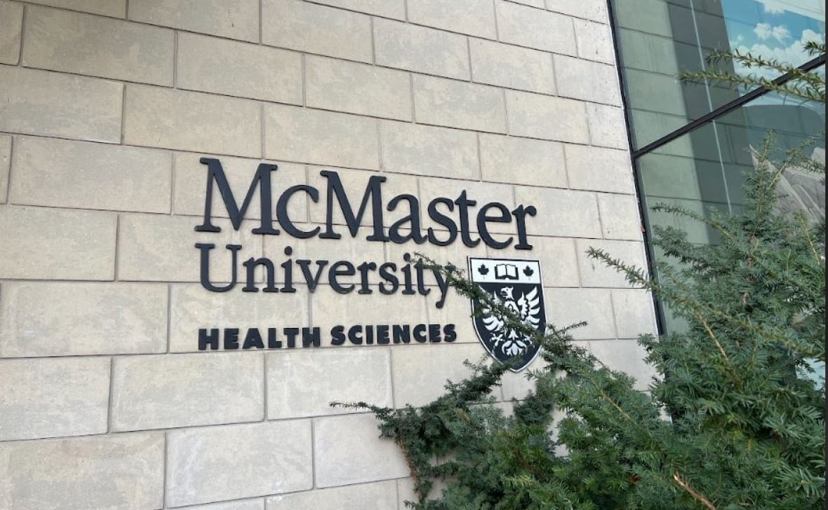 Wall with sign reading McMaster University Health Sciences and school logo. 