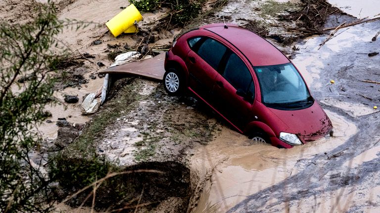 Cars are swept away by the water, after floods preceded by heavy rains caused the river to overflow its banks in the town of Alora, Malaga, Tuesday, Oct. 29, 2024. (AP Photo/Gregorio Marrero)