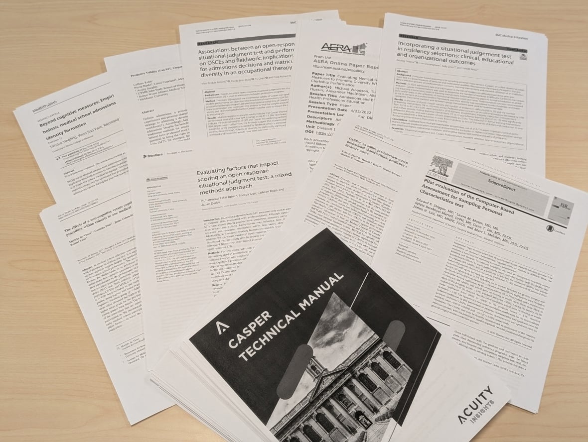 Black-and-white print-outs of scientific research laid out on a table. 